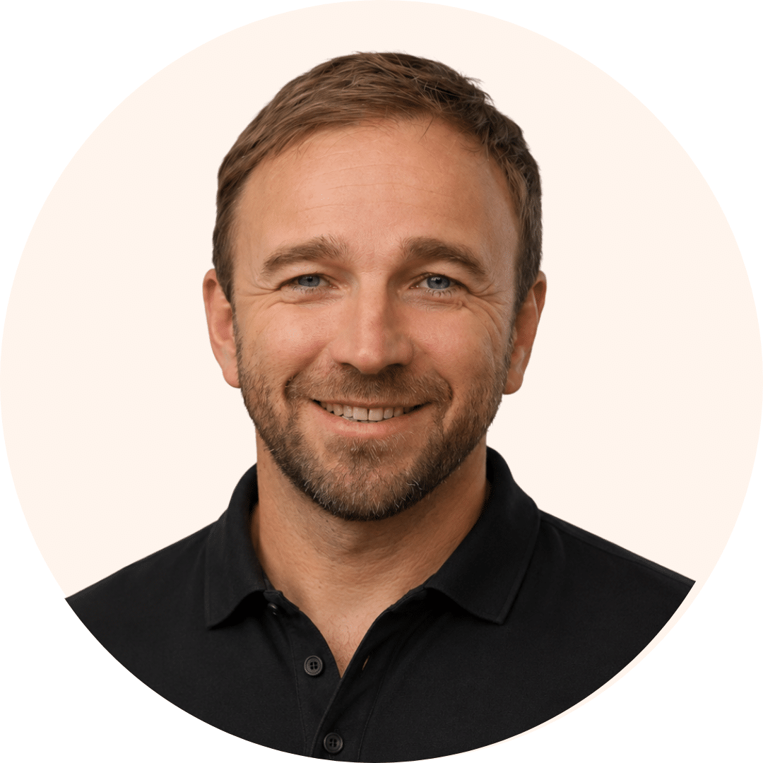 Smiling man with light brown hair and stubble wearing a black polo shirt, against a pale beige circular background (profile photo).